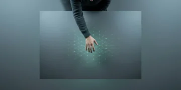 Une personne interagit avec une projection numérique verte et géométrique sur une surface sombre, symbolisant la redéfinition des interactions humaines par la culture numérique.