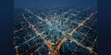 Photographie aérienne d'une métropole à l'aube, les lumières de la ville se mêlant à un motif lumineux de circuit imprimé vert-bleu, symbolisant les nouvelles frontières numériques et l'IA générative.